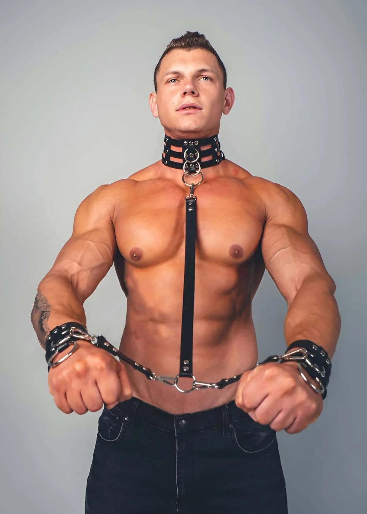 black faux leather wrist cuffs with dual silver O-rings and studded band detail