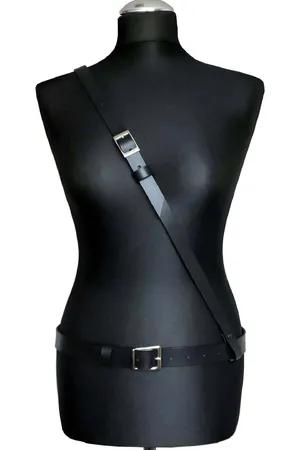 Minimalist black faux leather body harness with adjustable waist and shoulder straps and silver buckles.