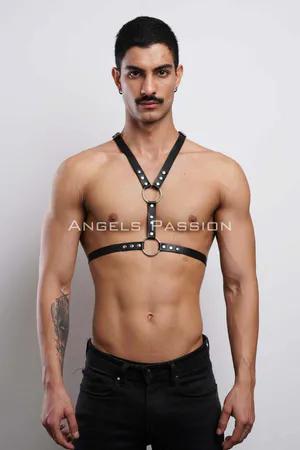 Black faux leather adjustable body harness with O-ring and rivets, worn by a male model.
