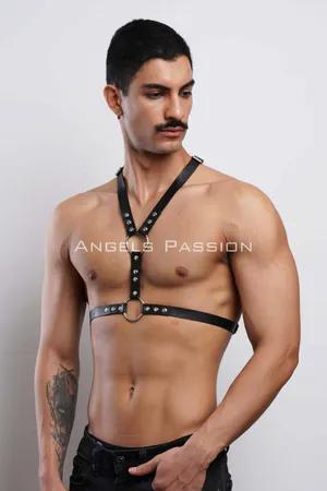 Black faux leather adjustable body harness with O-ring and rivets, worn by a male model.