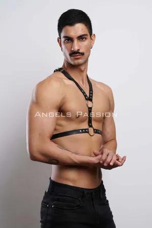 Black faux leather adjustable body harness with O-ring and rivets, worn by a male model.