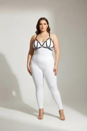 Black faux leather strappy chest harness with silver O-ring hardware, worn by a plus-size model.