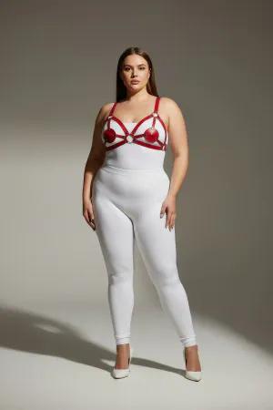 Red faux leather strappy harness with heart details and silver rings worn by a plus-size model