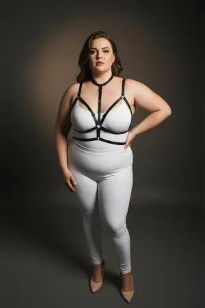 Black faux leather strappy body harness with central O-ring detail, worn by a plus-size model.