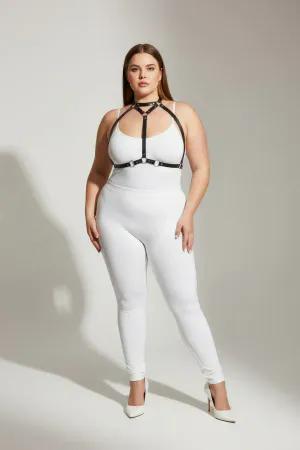 Black faux leather strappy body harness with silver O-rings and adjustable straps worn by a plus-size model.