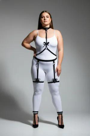 Black vegan leather body harness with choker, chest straps, O-rings, and decorative bow garter straps.
