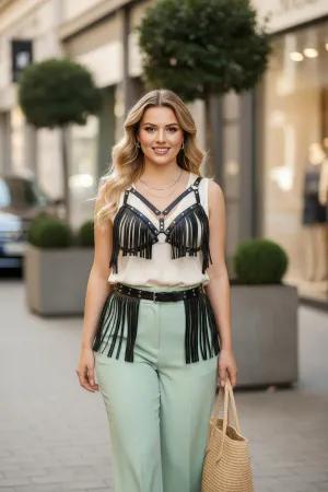 Black Fringe Faux Leather Chest Harness and Waist Belt Set worn over a cream top and mint trousers