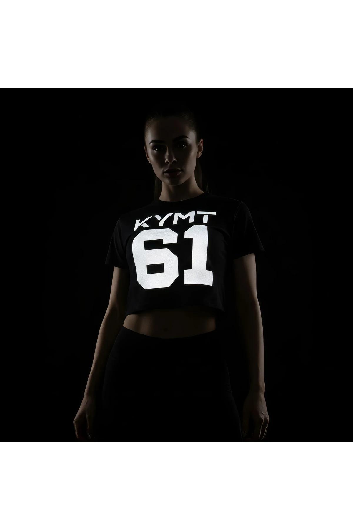 black reflective crop top t-shirt with large white KYMT 61 graphic glowing under direct light