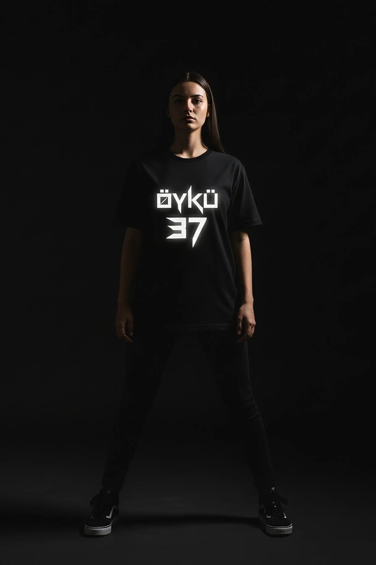 black oversized custom reflective graphic tee with personalized name and number print glowing in low light