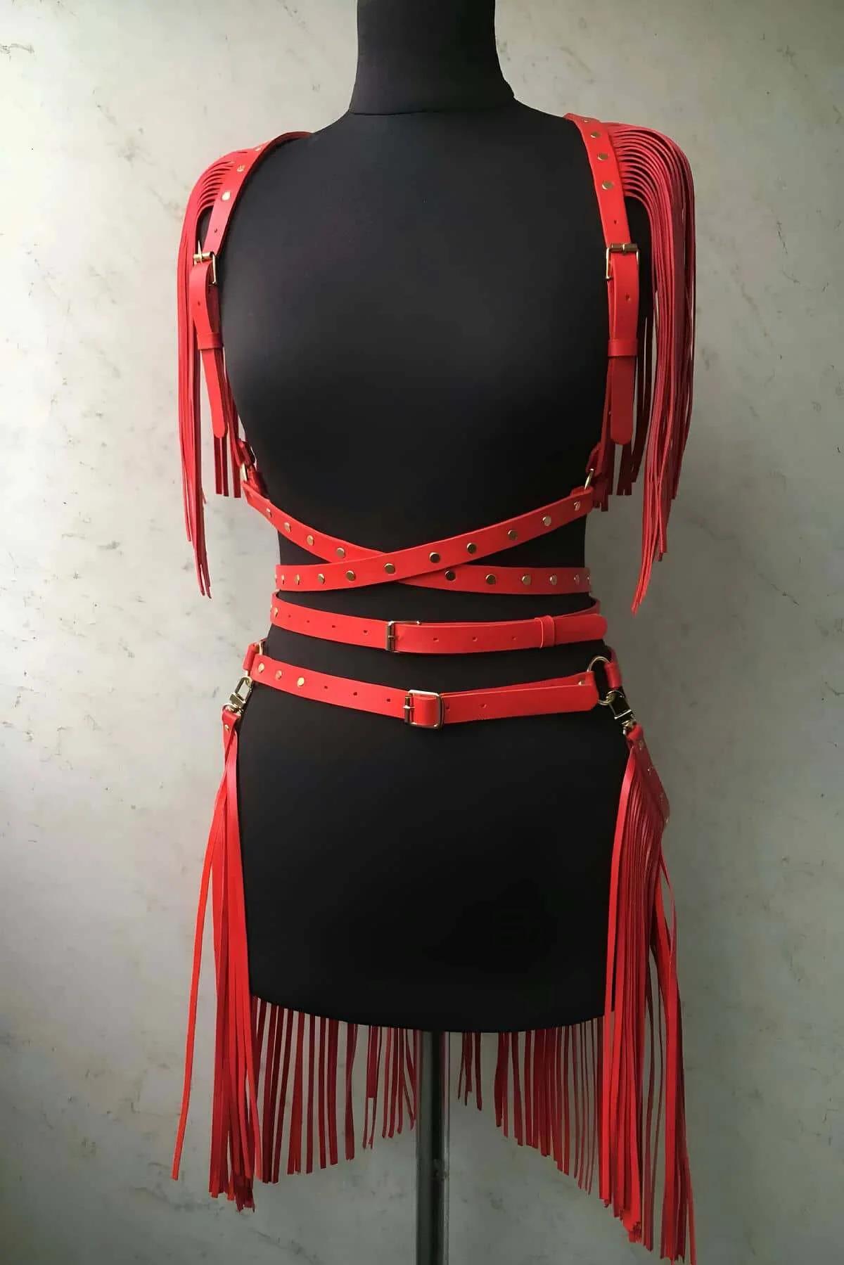 Red faux leather fringe harness set with gold studs — shoulder epaulettes and waist skirt belt on mannequin