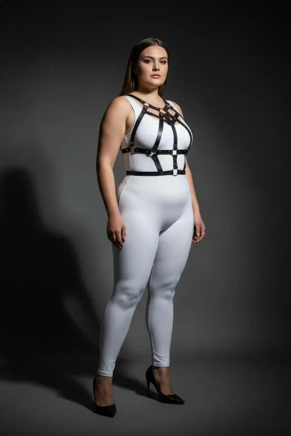 Black faux leather strappy body harness with silver stud rivets cage-grid chest design on plus-size model