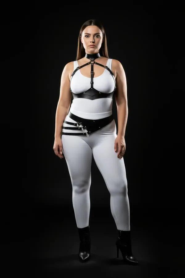 black faux leather full body harness with chest cage collar and diagonal hip belt worn over white bodysuit plus size model