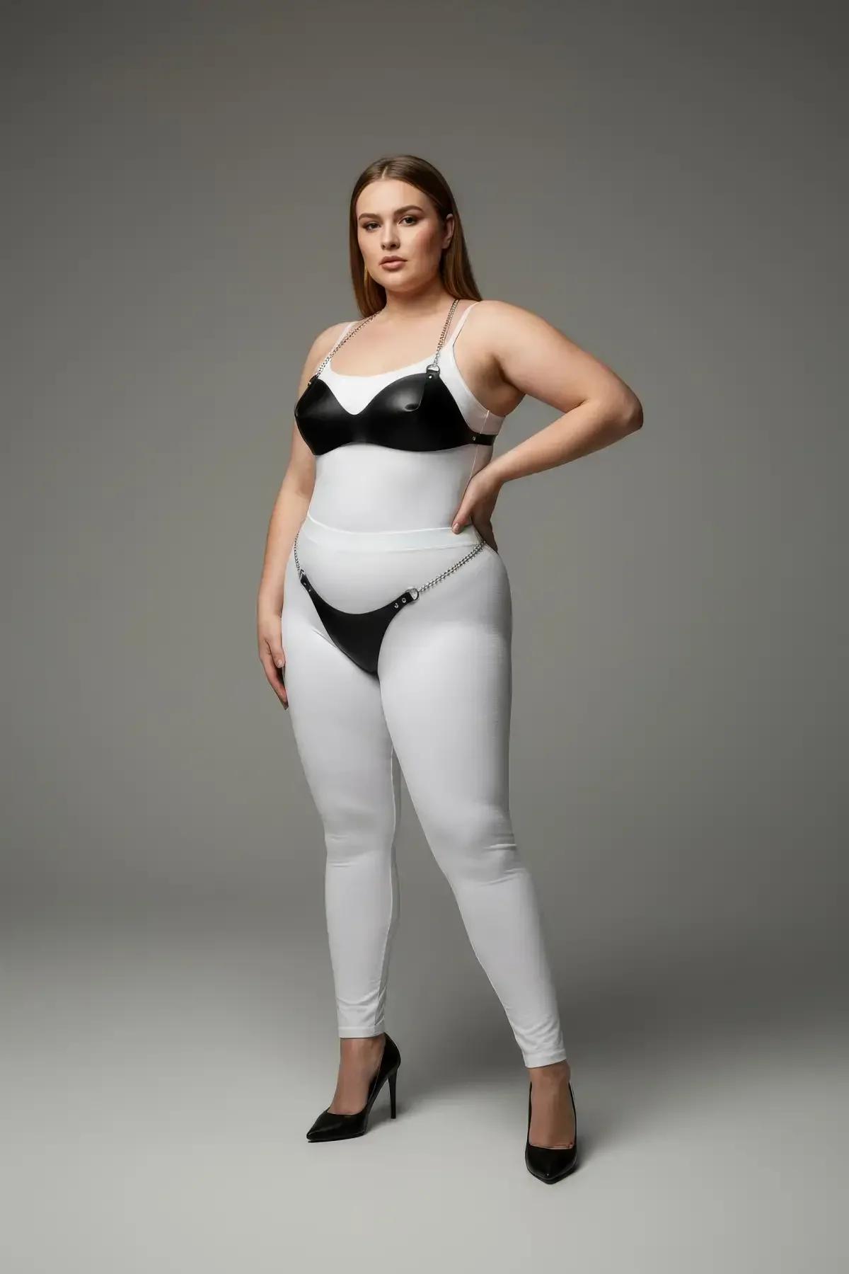 black faux leather bra and garter harness set with silver chain accents worn over white leggings, two-piece intimate fashion