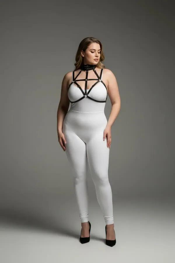 black faux leather strappy chest harness with choker neck and silver O-ring hardware worn over white bodysuit