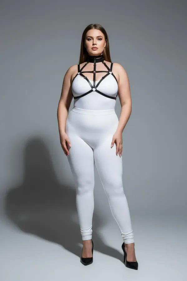black faux leather strappy chest harness with choker neck and silver O-ring hardware worn over white bodysuit