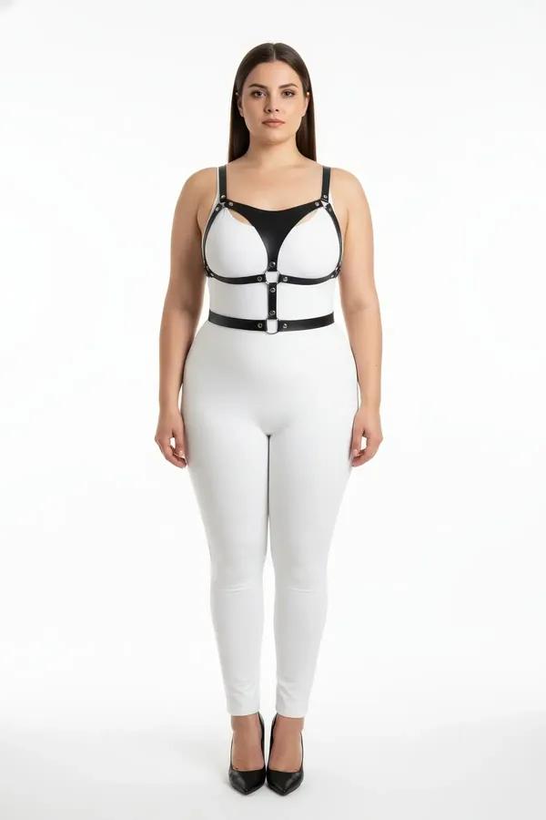 black faux leather strappy body harness with cage chest cutouts and silver O-ring hardware worn over white outfit