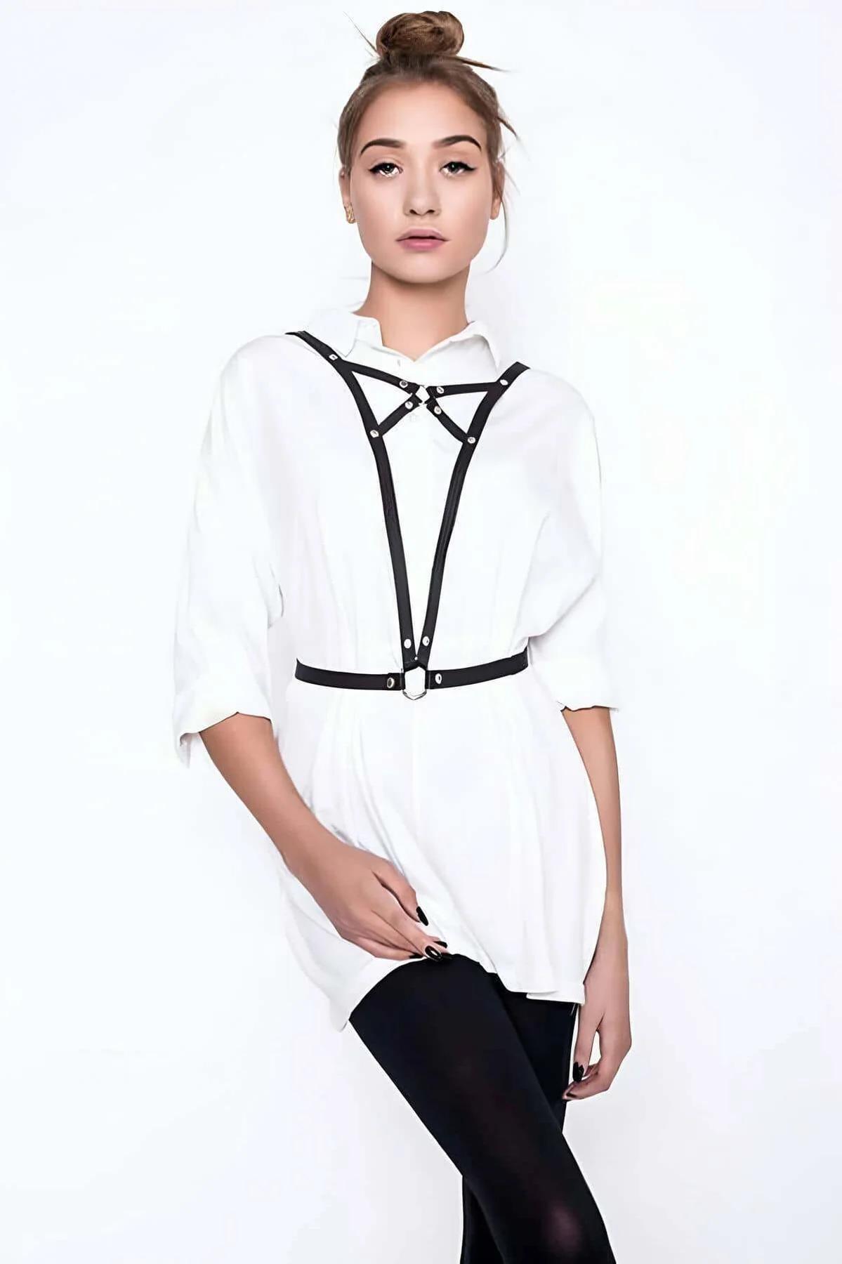 Black faux leather chest harness with silver O-ring worn over white shirt, adjustable strap style