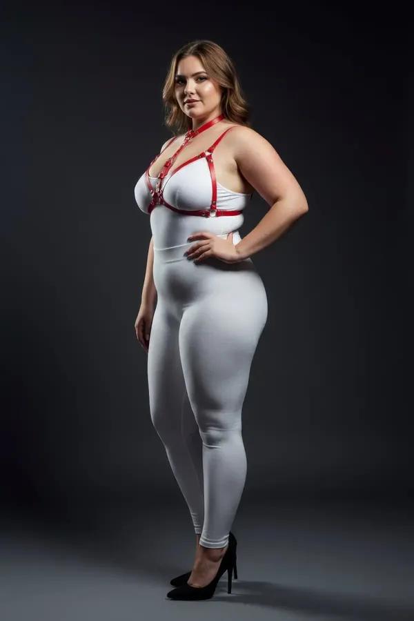 Red faux leather strappy harness bra with silver O-ring details worn over white outfit, plus-size model