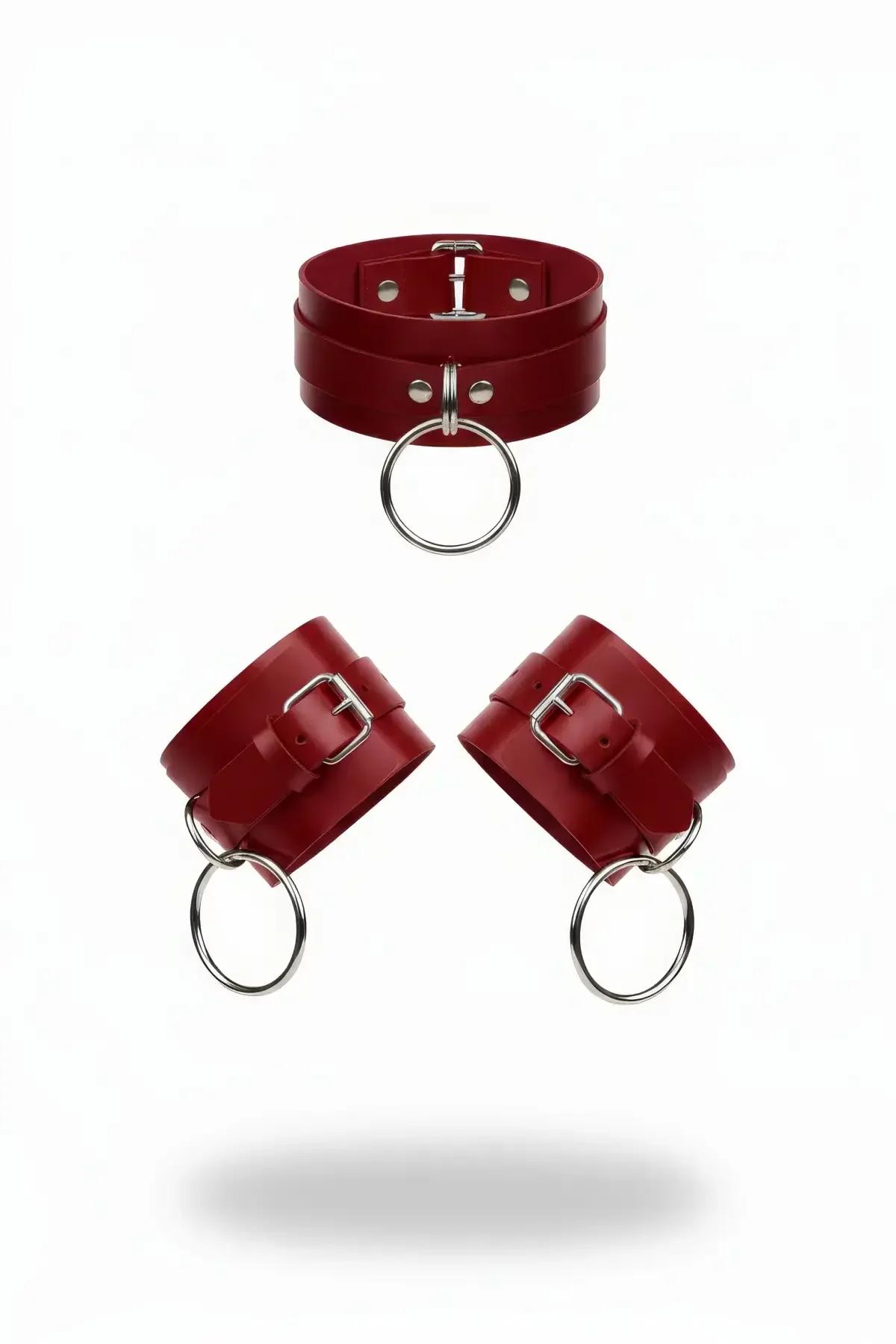Red faux leather O-ring choker and wrist cuffs set with silver buckles on white background