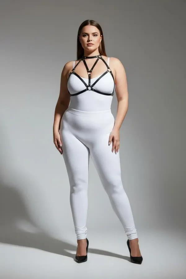 black faux leather strappy body harness with gold O-ring detail and choker collar worn over white bodysuit