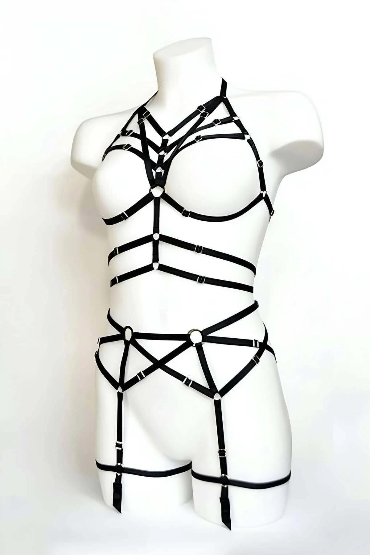 Black elastic full body cage harness set with caged bra, horizontal waist bands, and adjustable thigh garters displayed on wh