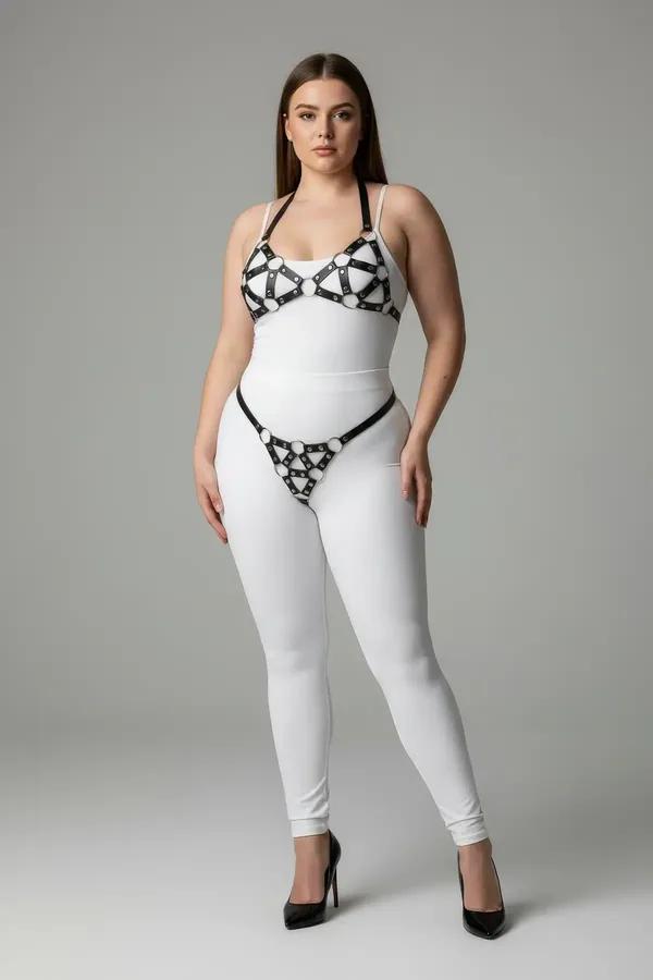 black faux leather cage harness bra and garter belt set with silver O-rings worn over white bodysuit