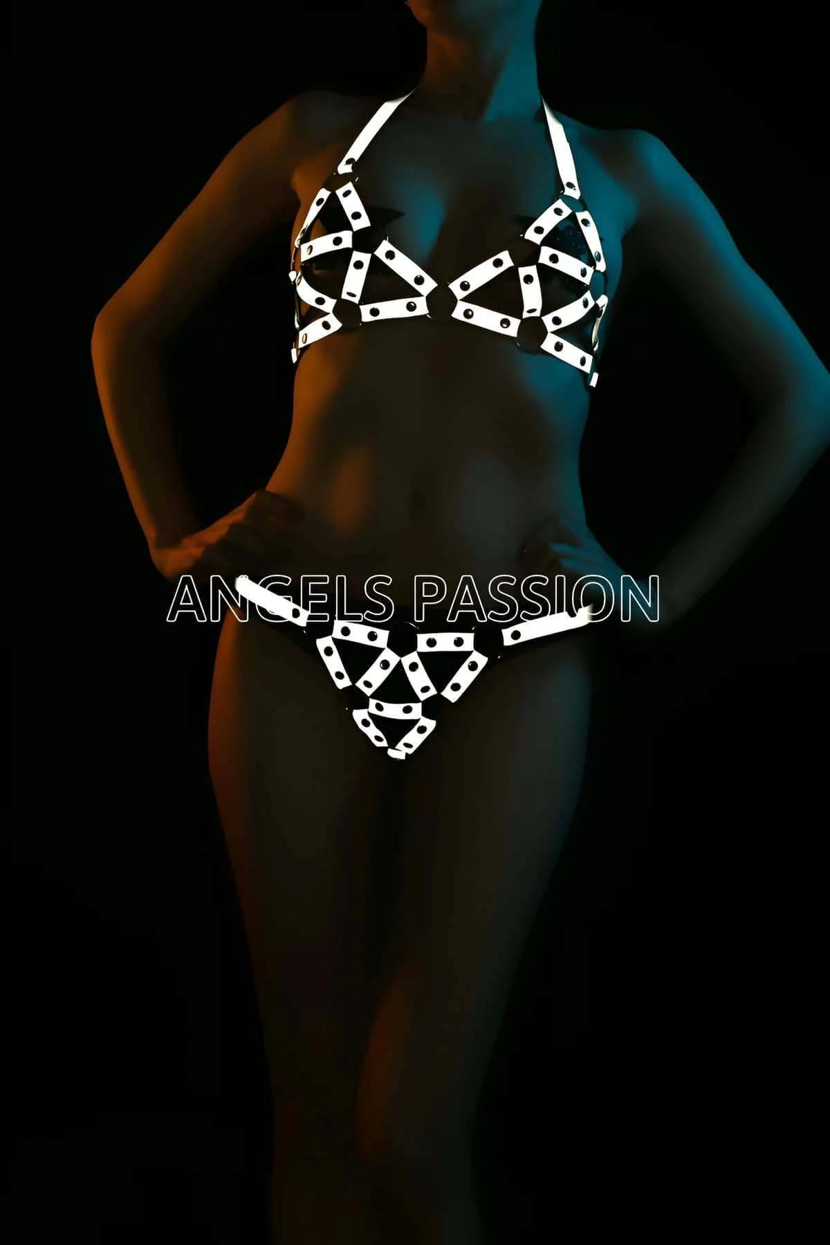White reflective geometric harness bra and briefs set with angular strap panels and circular rivet hardware glowing under sta