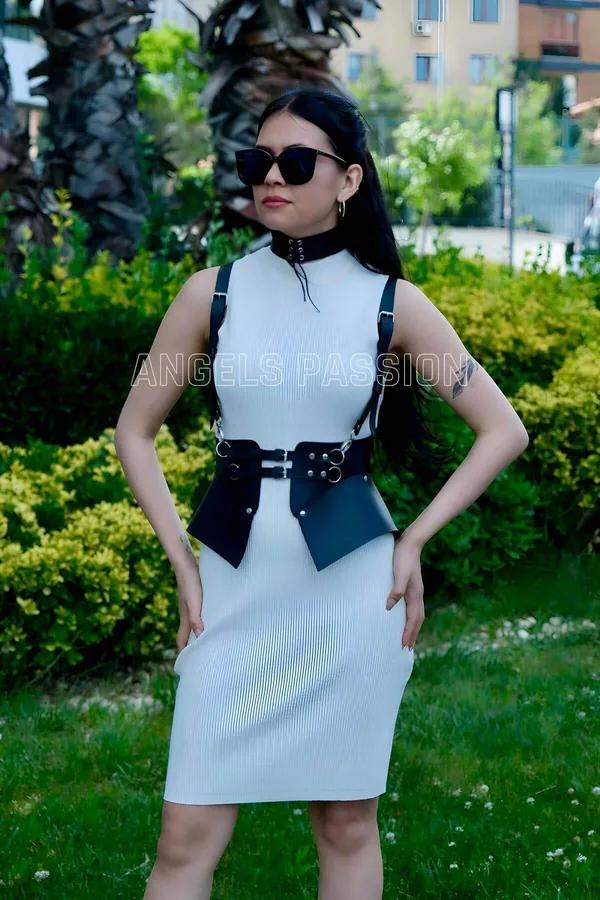 siyah suni deri vücut harness ve choker takım, gümüş O-ring ve tokalar, belde mini kılıf çanta, beyaz elbise üzerine giyilmiş