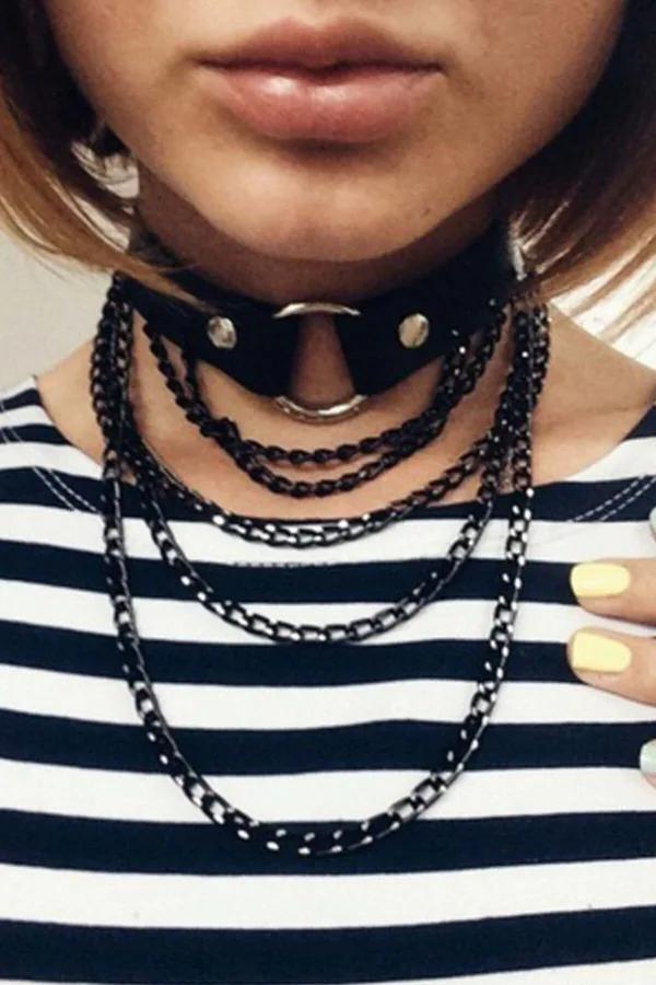 black faux leather layered chain choker with silver O-ring and four cascading black metal chains worn at throat