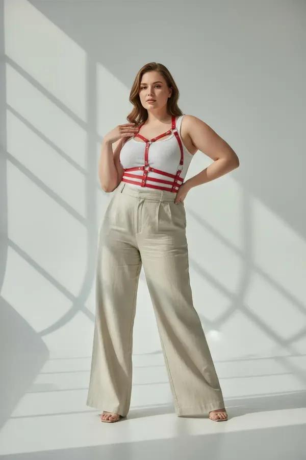red faux leather strappy chest and waist harness with silver O-rings worn over white t-shirt