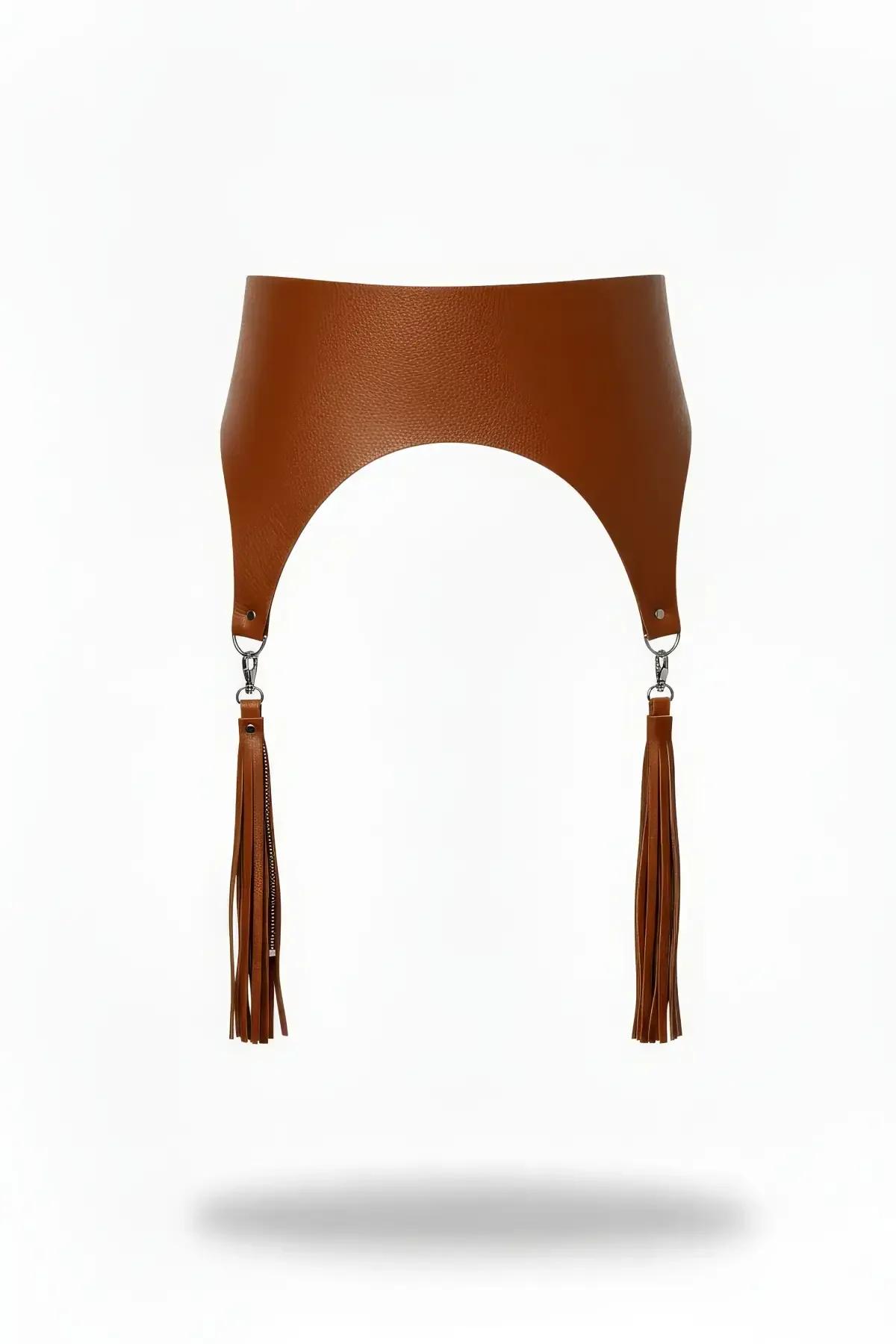 Wide tan faux leather waist harness with arched hem, silver D-rings, and long faux leather tassels with zipper-pull accents