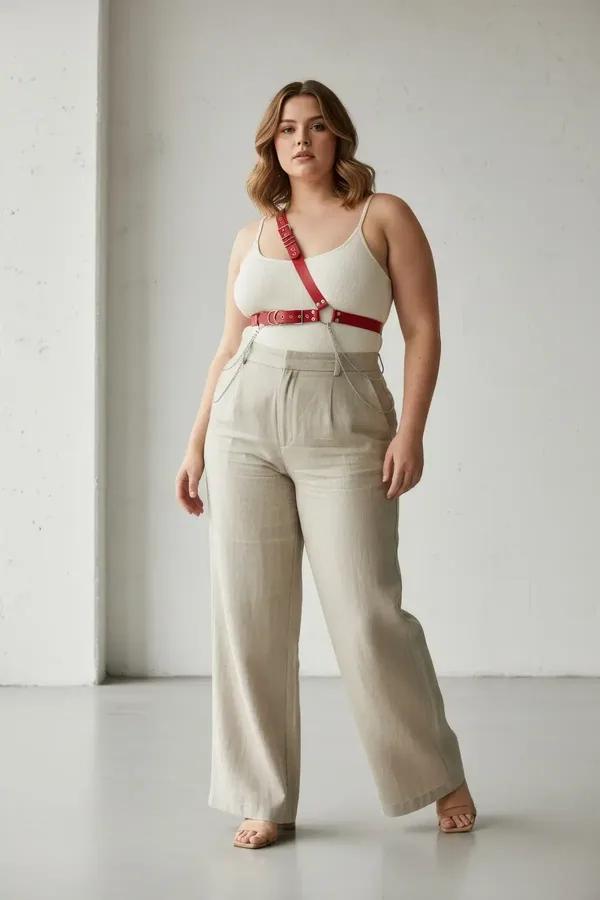 red faux leather single shoulder body harness with silver studs and O-ring worn over white tank top