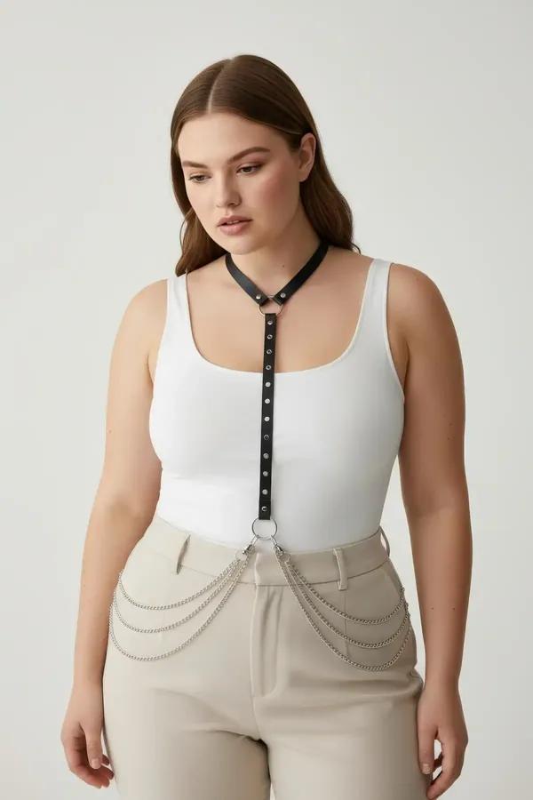 Black faux leather rivet embellished chest harness with cascading silver hip chains worn over white tank