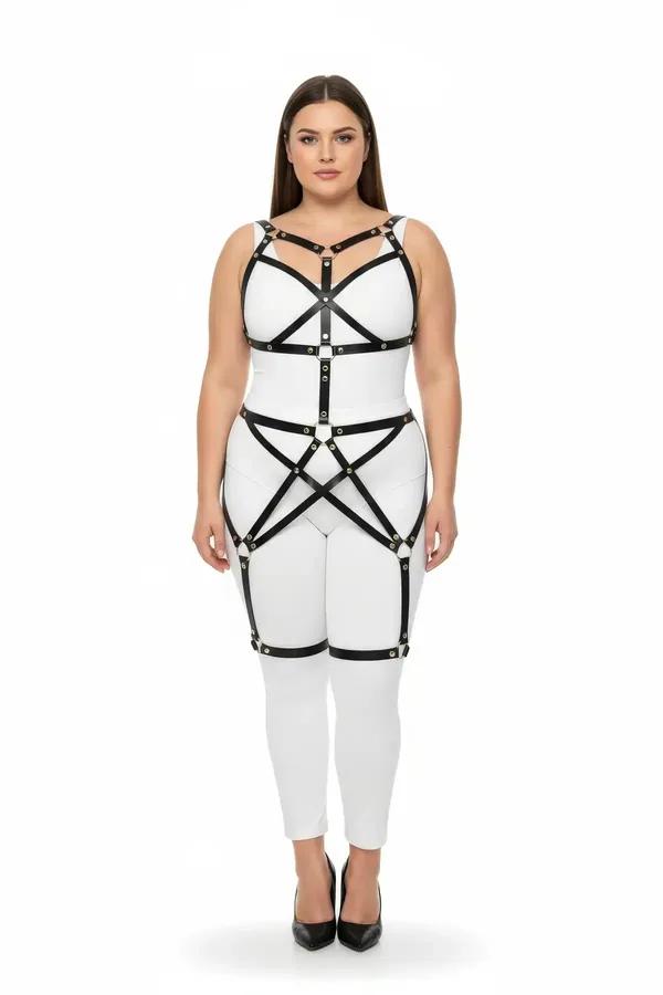 black faux leather full body cage harness with gold O-ring hardware worn over white bodysuit, chest and thigh straps visible