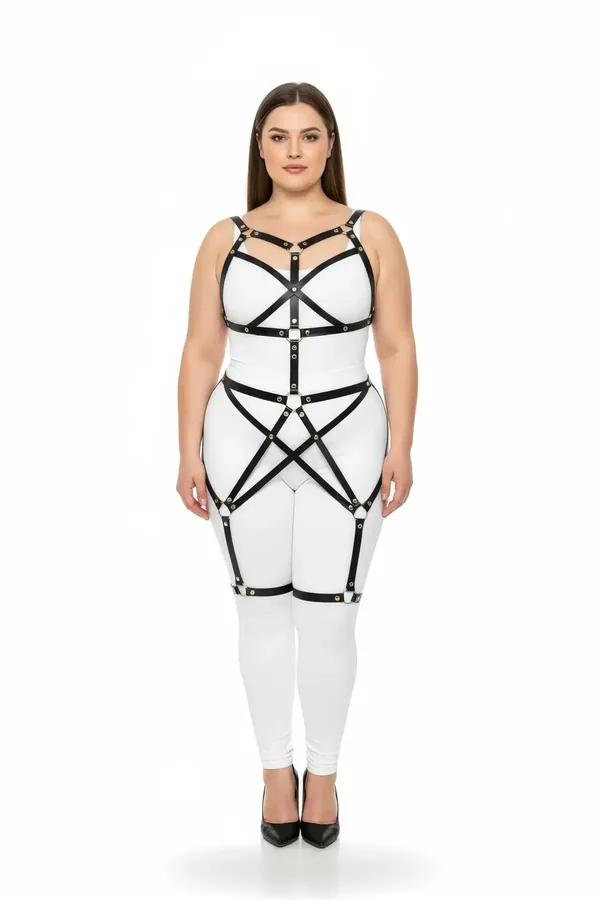 black faux leather full body cage harness with gold O-ring hardware worn over white bodysuit, chest and thigh straps visible