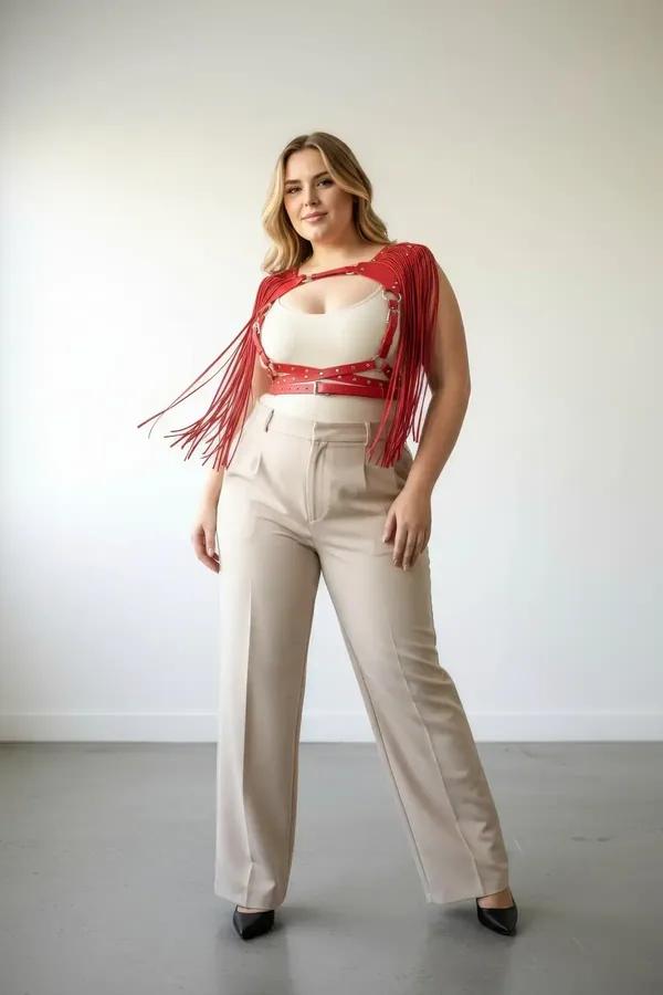 red faux leather fringe body harness with silver studded straps and O-rings worn over cream crop top