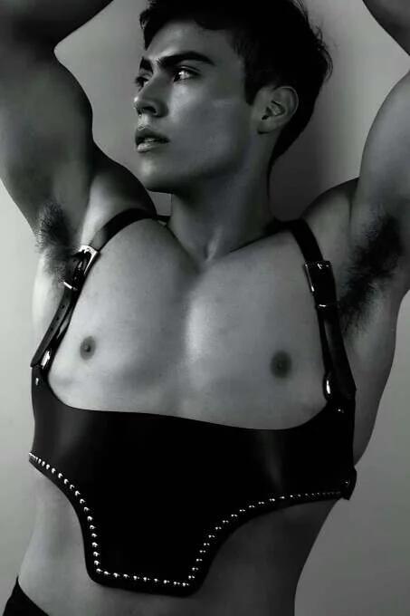Black faux leather underbust harness with silver stud trim along hem and silver buckle adjustable shoulder straps on male mod