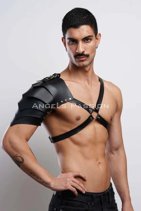 Black faux leather shoulder harness with segmented pauldron panels and O-ring chest strap on male model