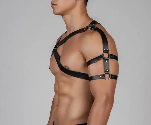 black vegan leather asymmetric chest harness with single shoulder strap, two silver O-rings, rivet studs, and separate upper