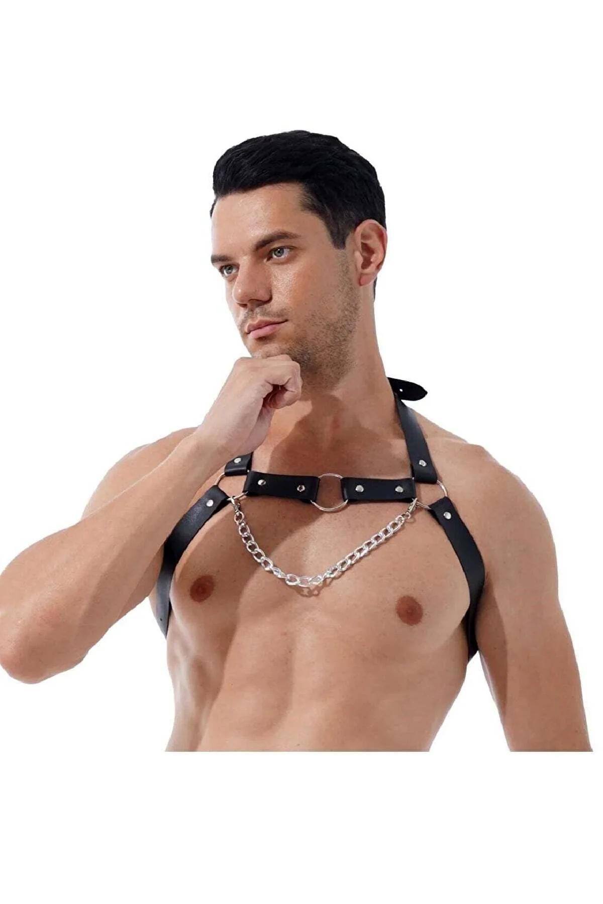 Black faux leather chest harness with silver O-ring and curb chain worn by male model, front view