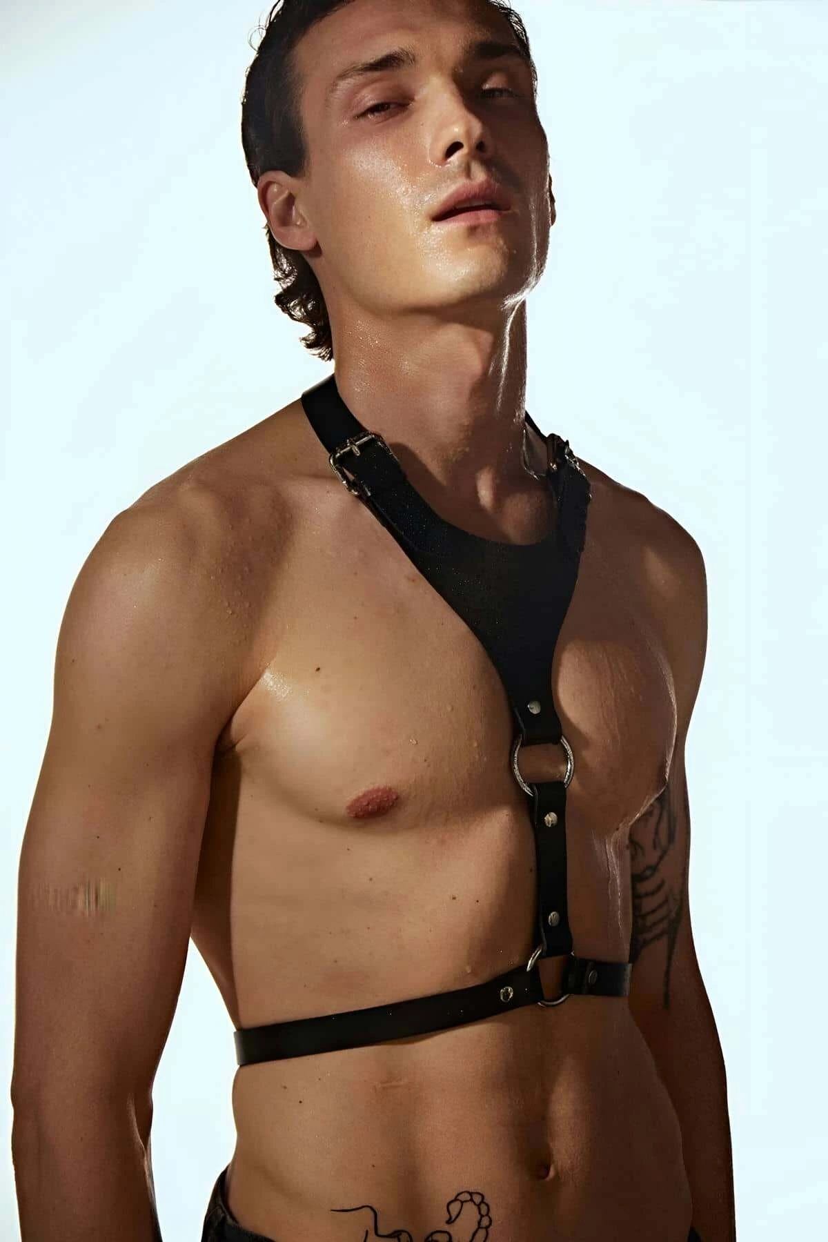 Black faux leather adjustable O-ring chest harness worn by a person.