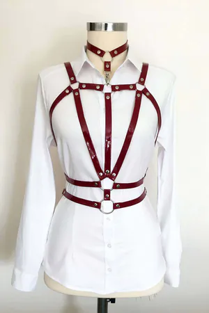 Crimson patent halterneck body harness with silver O-ring hardware on white shirt