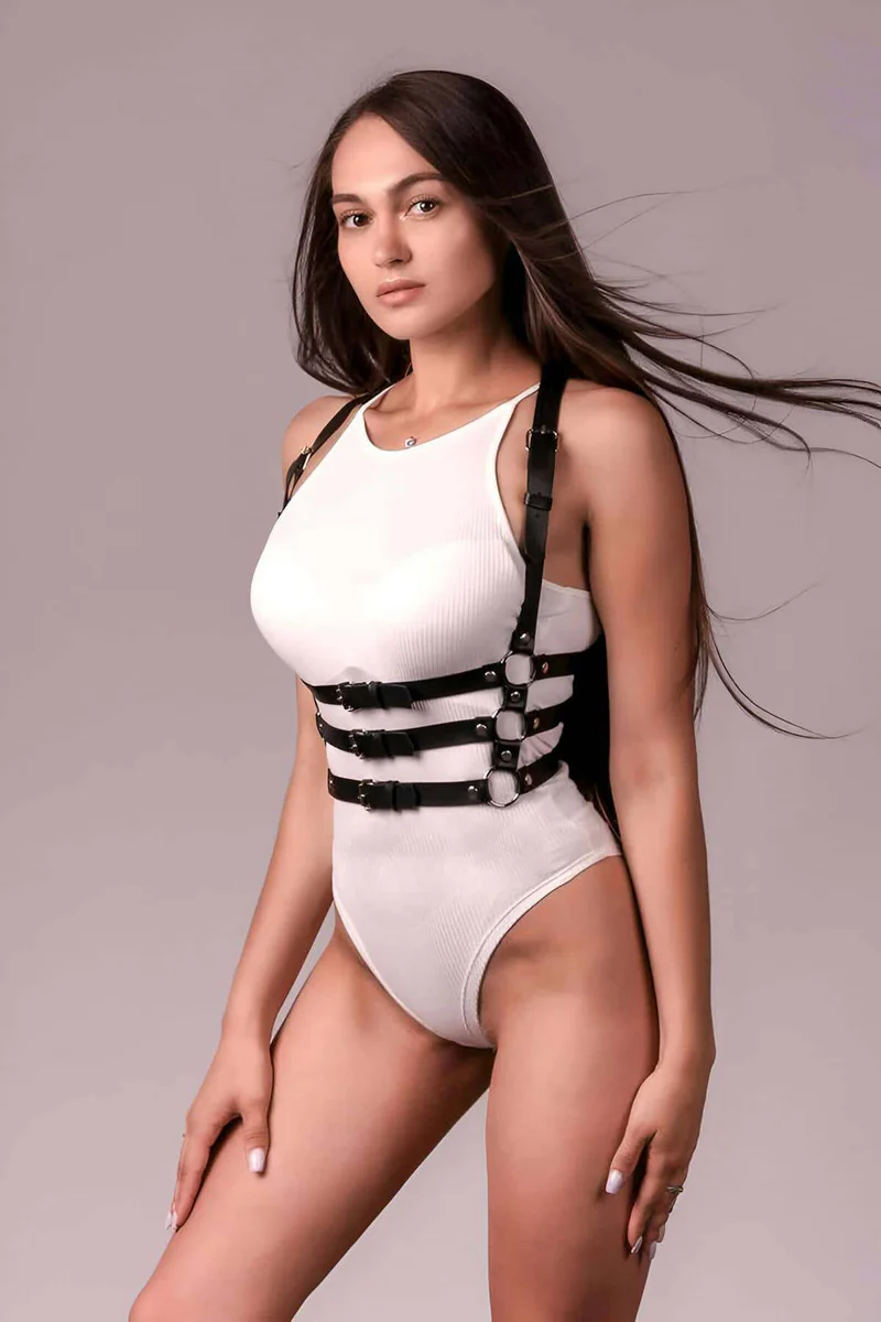 Black faux leather body harness close-up on buckles and straps