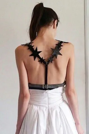 Black faux leather star back body harness with adjustable waist belt worn by a model