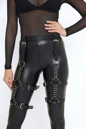 Siyah deri bacak harness, gümüş renkli metal halkalar ve tokalar ile süslenmiş, ayarlanabilir kayışlı