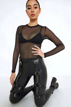 Siyah deri bacak harness, gümüş renkli metal halkalar ve tokalar ile süslenmiş, ayarlanabilir kayışlı