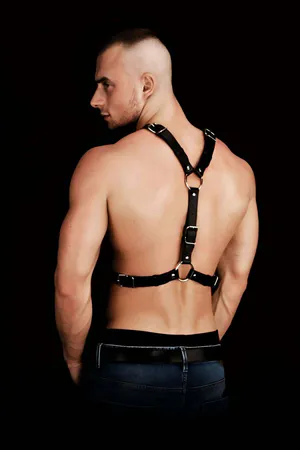 Black faux leather chest harness with O-ring and stud details