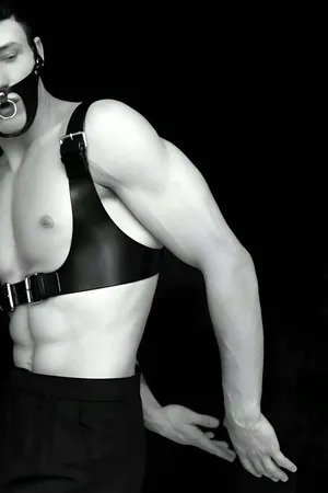 Black faux leather full body harness with detachable O-ring gag mask, silver buckle details.