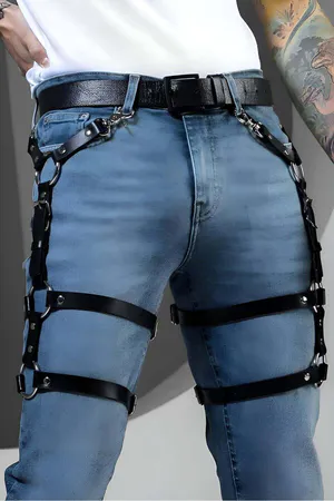 Adjustable black faux leather leg harness with silver O-rings attached to a belt