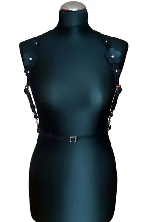 Black faux leather chest harness with floral appliqués on shoulder straps